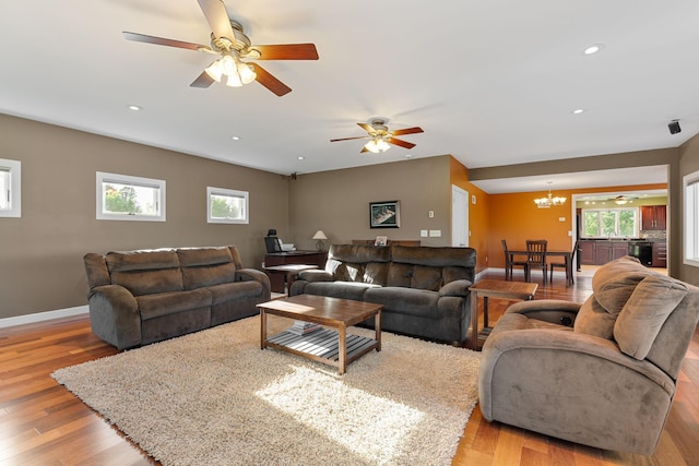 living area with a chandelier, light wood-type flooring, plenty of natural light, and recessed lighting