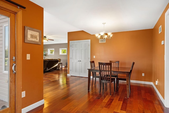 dining room featuring hardwood / wood-style flooring, a chandelier, and baseboards