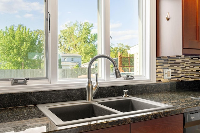 kitchen featuring a sink, backsplash, and stainless steel dishwasher