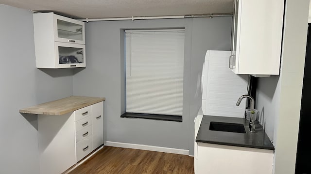 1824 5th St Unit A, Minneapolis, MN 55454 - kitchen with a sink, dark wood-style flooring, white cabinets, glass insert cabinets, and a textured ceiling