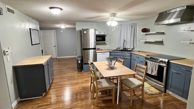 1824 5th St Unit A, Minneapolis, MN 55454 - kitchen featuring appliances with stainless steel finishes, butcher block counters, ventilation hood, blue cabinetry, and open shelves