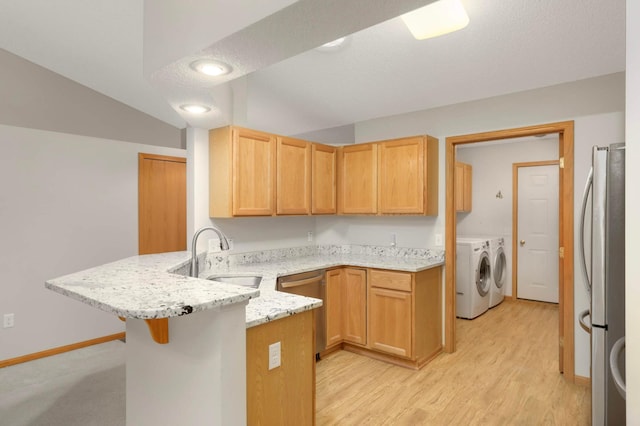 9432 Prairieview Trl N, Champlin, MN 55316 - kitchen featuring a peninsula, a sink, appliances with stainless steel finishes, washer and clothes dryer, and light stone countertops