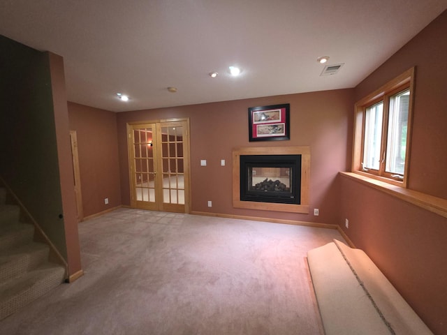 7390 360th St, North Branch, MN 55056 - unfurnished living room featuring light colored carpet, a multi sided fireplace, french doors, recessed lighting, and stairs
