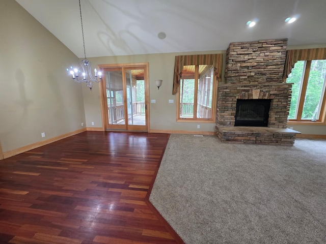 7390 360th St, North Branch, MN 55056 - unfurnished living room featuring a chandelier, vaulted ceiling, wood finished floors, a fireplace, and baseboards