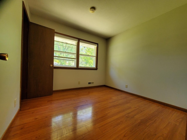 unfurnished room featuring wood finished floors and baseboards