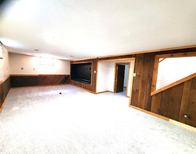 carpeted spare room with wood walls