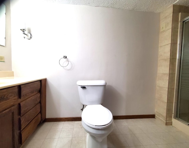 full bathroom featuring vanity, a stall shower, toilet, baseboards, and a textured ceiling