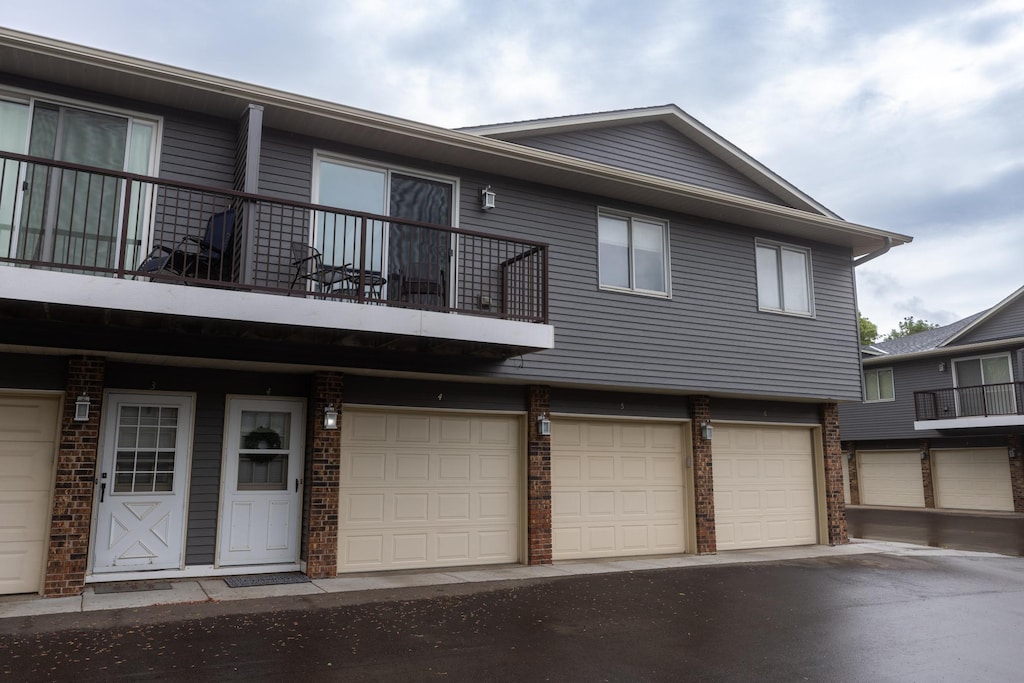 2041 Park Dr Unit 20414, Saint Paul, MN 55119 - view of front of property featuring a balcony, brick siding, and an attached garage