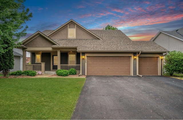 10025 Toledo Dr N, Brooklyn Park, MN 55443 - view of front facade with a garage, driveway, a shingled roof, a front yard, and a porch