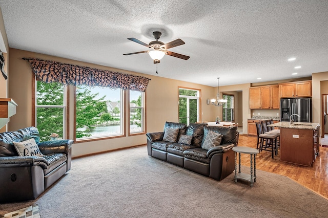 10025 Toledo Dr N, Brooklyn Park, MN 55443 - living room featuring a chandelier, a ceiling fan, a textured ceiling, recessed lighting, and light wood-type flooring