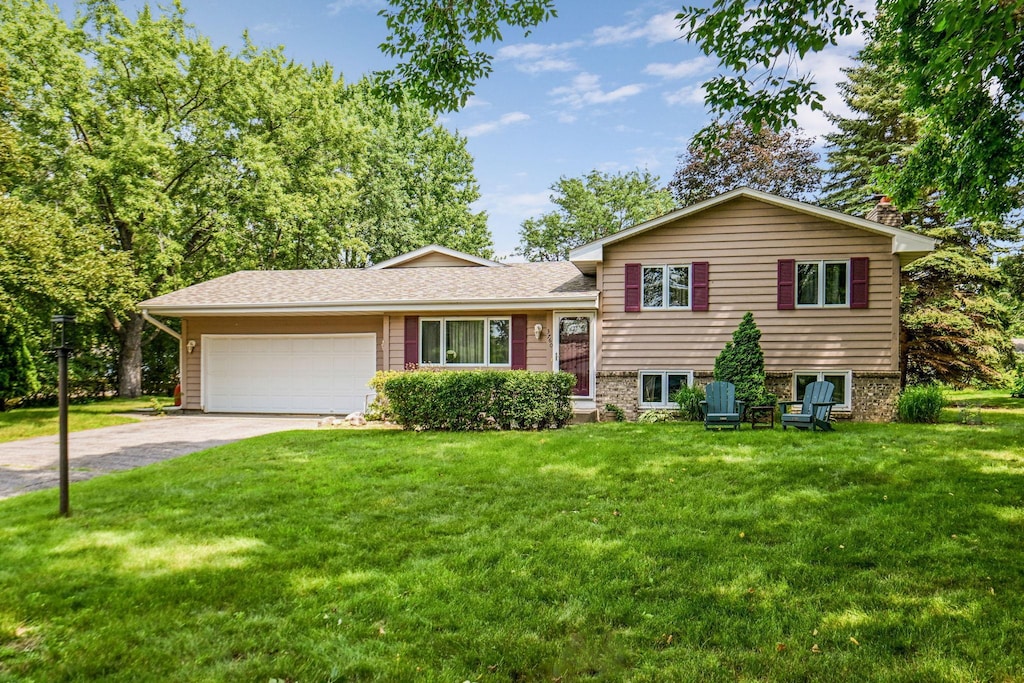 3760 Trenton Ln N, Plymouth, MN 55441 - tri-level home with an attached garage, a front yard, and concrete driveway