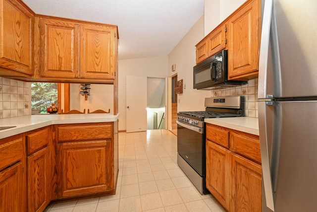 3760 Trenton Ln N, Plymouth, MN 55441 - kitchen with appliances with stainless steel finishes, tasteful backsplash, light countertops, and brown cabinets
