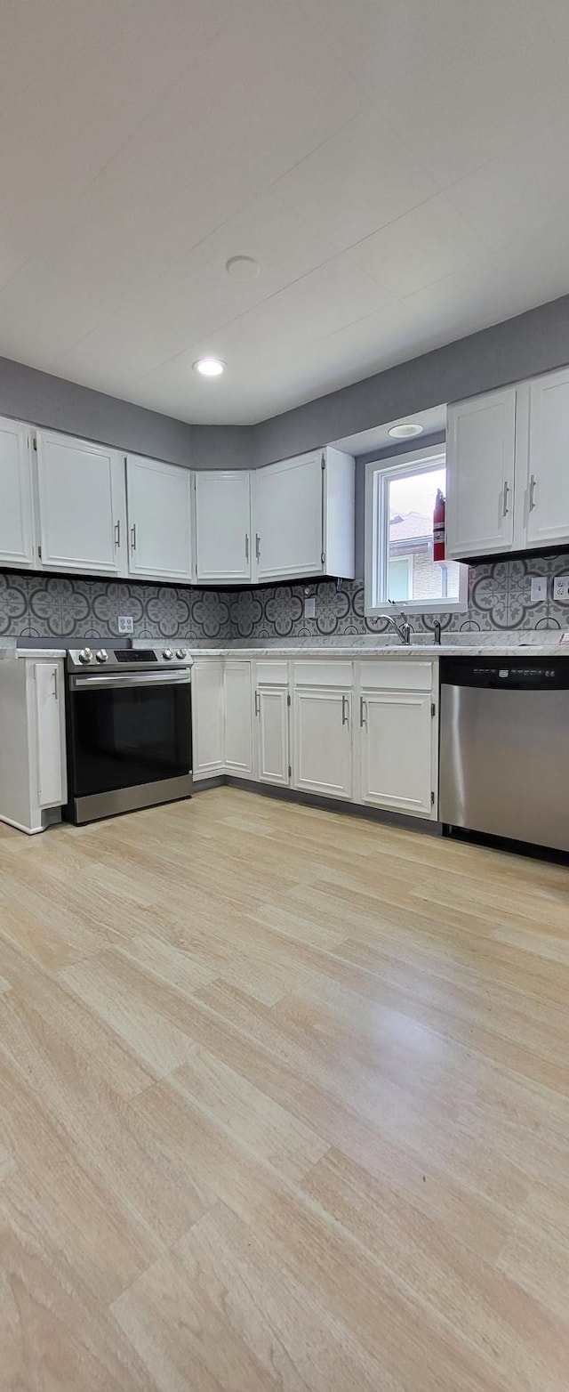 5252 Queen Ave N, Minneapolis, MN 55430 - kitchen with stainless steel appliances, tasteful backsplash, and white cabinets