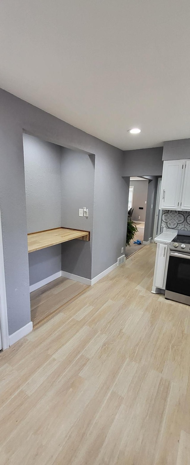 5252 Queen Ave N, Minneapolis, MN 55430 - kitchen with stainless steel electric range, light wood-style floors, white cabinetry, and light countertops