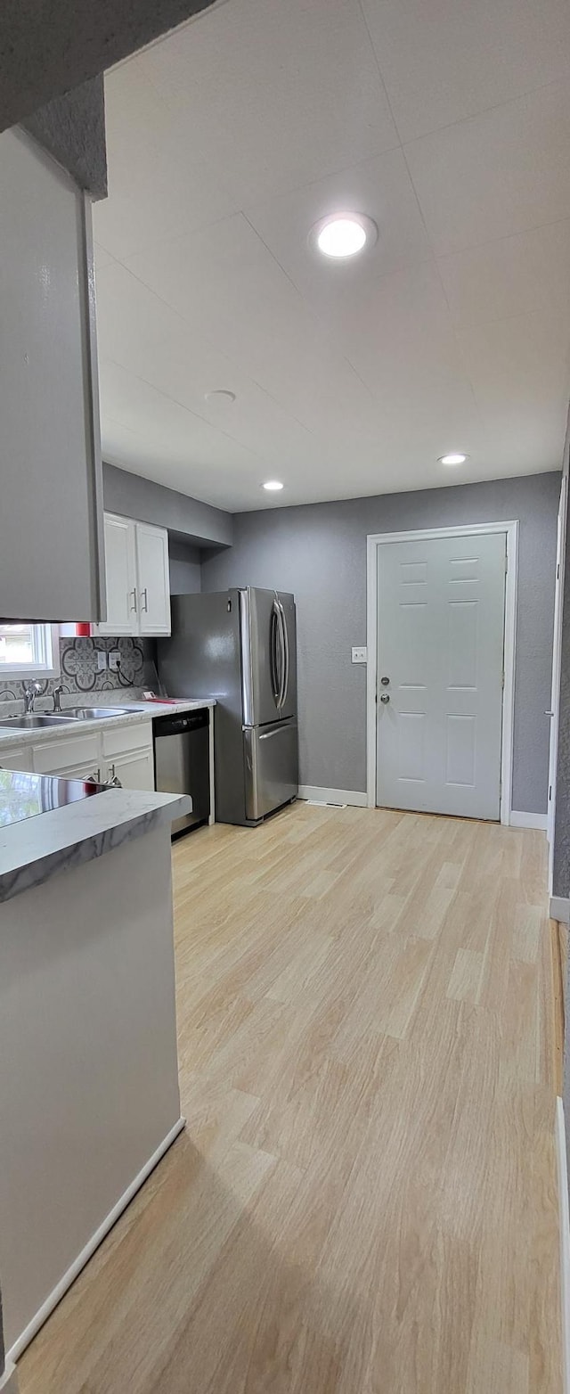 5252 Queen Ave N, Minneapolis, MN 55430 - kitchen featuring appliances with stainless steel finishes, white cabinets, light wood-style floors, light countertops, and recessed lighting
