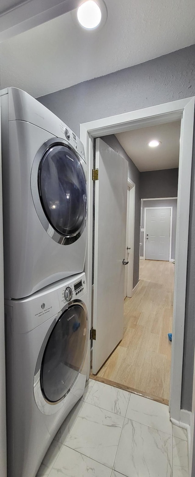5252 Queen Ave N, Minneapolis, MN 55430 - laundry room with stacked washer and clothes dryer, light marble finish floors, and recessed lighting