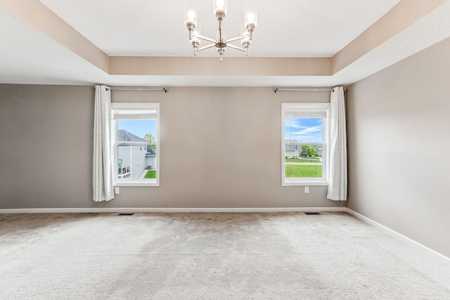 11632 Riverstone Trl, Woodbury, MN 55129 - carpeted empty room with a chandelier, baseboards, and a raised ceiling
