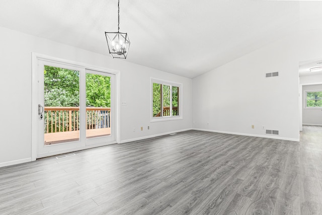500 Ridge Ln, Chaska, MN 55318 - unfurnished living room featuring vaulted ceiling, wood finished floors, a chandelier, and baseboards