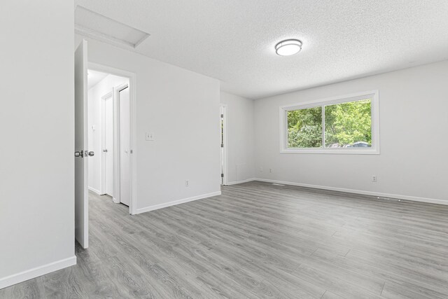 500 Ridge Ln, Chaska, MN 55318 - empty room featuring attic access, a textured ceiling, wood finished floors, and baseboards