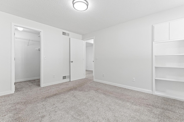 500 Ridge Ln, Chaska, MN 55318 - unfurnished bedroom with carpet flooring, a spacious closet, a textured ceiling, baseboards, and a closet
