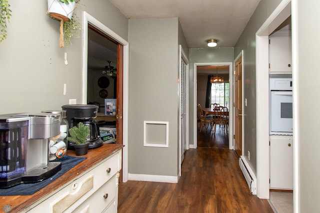 1513 40th Ave N, Moorhead, MN 56560 - corridor featuring a baseboard radiator, dark wood finished floors, baseboards, and a chandelier