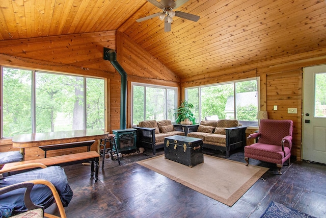 1513 40th Ave N, Moorhead, MN 56560 - living room featuring vaulted ceiling, a wood stove, a ceiling fan, wood walls, and dark wood finished floors