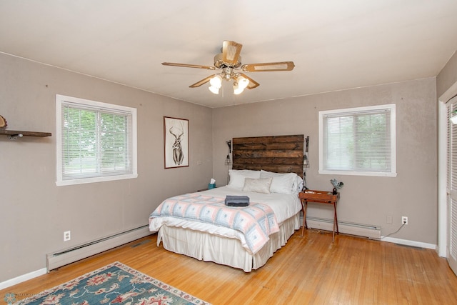 1513 40th Ave N, Moorhead, MN 56560 - bedroom featuring baseboard heating, wood finished floors, and ceiling fan