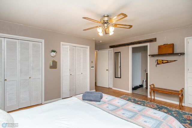 1513 40th Ave N, Moorhead, MN 56560 - bedroom featuring two closets, wood finished floors, baseboards, and ceiling fan