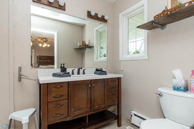 1513 40th Ave N, Moorhead, MN 56560 - bathroom with baseboard heating, toilet, vanity, and a ceiling fan