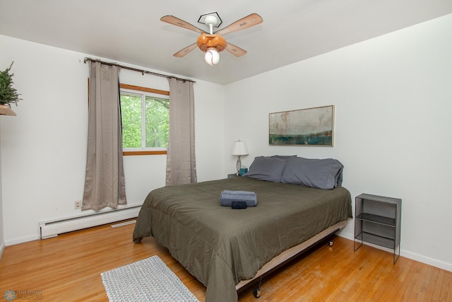 1513 40th Ave N, Moorhead, MN 56560 - bedroom featuring baseboard heating, wood finished floors, baseboards, and ceiling fan