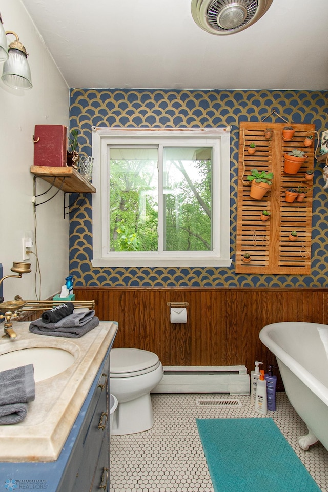 1513 40th Ave N, Moorhead, MN 56560 - bathroom with wallpapered walls, a baseboard heating unit, a freestanding bath, toilet, and vanity