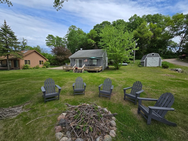 8137 Hoyt Ave SW, Victor Twp, MN 55349 - view of grassy yard with a deck and a fire pit