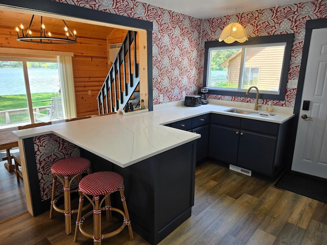 8137 Hoyt Ave SW, Victor Twp, MN 55349 - kitchen with wallpapered walls, a sink, a peninsula, plenty of natural light, and light countertops