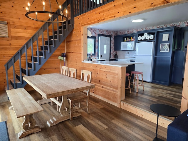 8137 Hoyt Ave SW, Victor Twp, MN 55349 - dining space with wood finished floors, stairs, wooden walls, and a chandelier