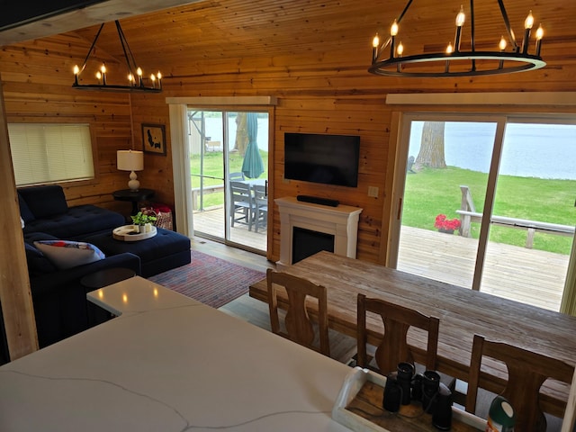 8137 Hoyt Ave SW, Howard Lake, MN 55349 - living room with a chandelier, wooden walls, wood finished floors, and a fireplace