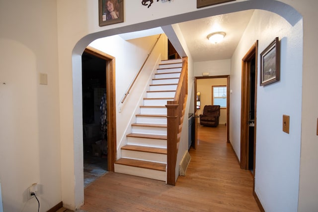 40515 442nd St, Sauk Centre Twp, MN 56378 - hallway featuring light wood-style flooring, arched walkways, and stairway