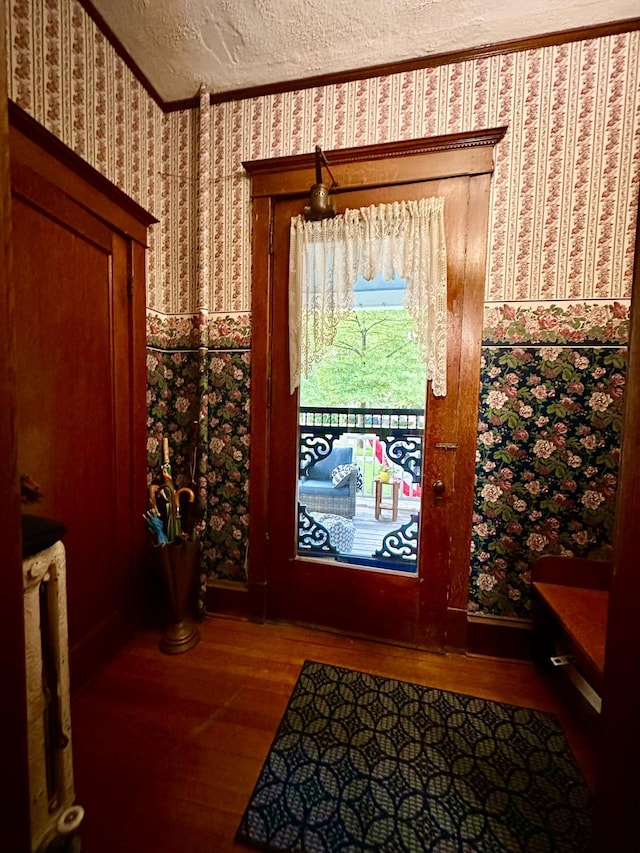 573 Rowland St, Tracy, MN 56175 - entryway featuring wood finished floors, wallpapered walls, a textured ceiling, and crown molding