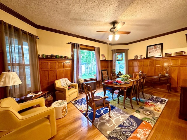 573 Rowland St, Tracy, MN 56175 - dining room featuring crown molding, ceiling fan, wood finished floors, a textured ceiling, and healthy amount of natural light