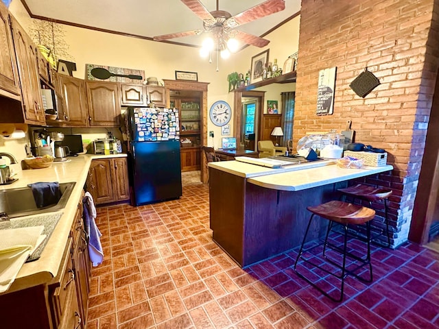573 Rowland St, Tracy, MN 56175 - kitchen with freestanding refrigerator, brick patterned flooring, a peninsula, light countertops, and a sink
