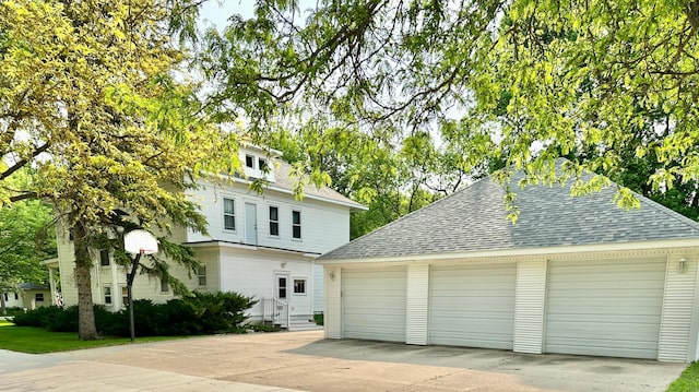 573 Rowland St, Tracy, MN 56175 - view of front of house featuring a shingled roof, a detached garage, and an outbuilding