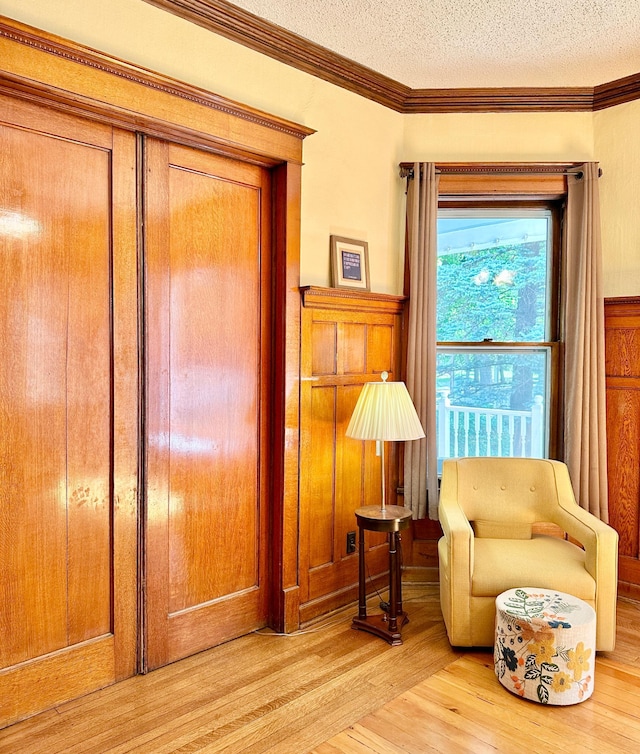 573 Rowland St, Tracy, MN 56175 - sitting room with light wood finished floors, a textured ceiling, and crown molding