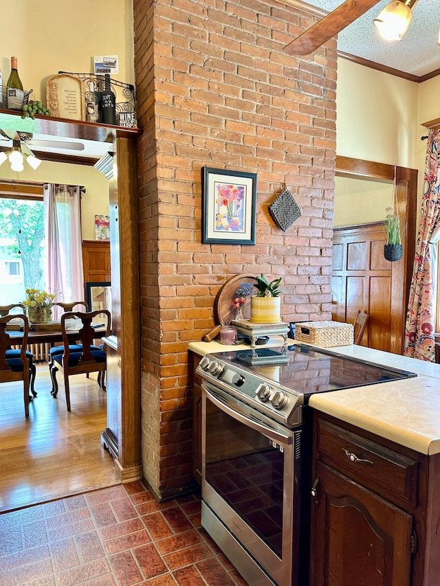 573 Rowland St, Tracy, MN 56175 - kitchen with stainless steel range with electric cooktop, ceiling fan, crown molding, light countertops, and wainscoting