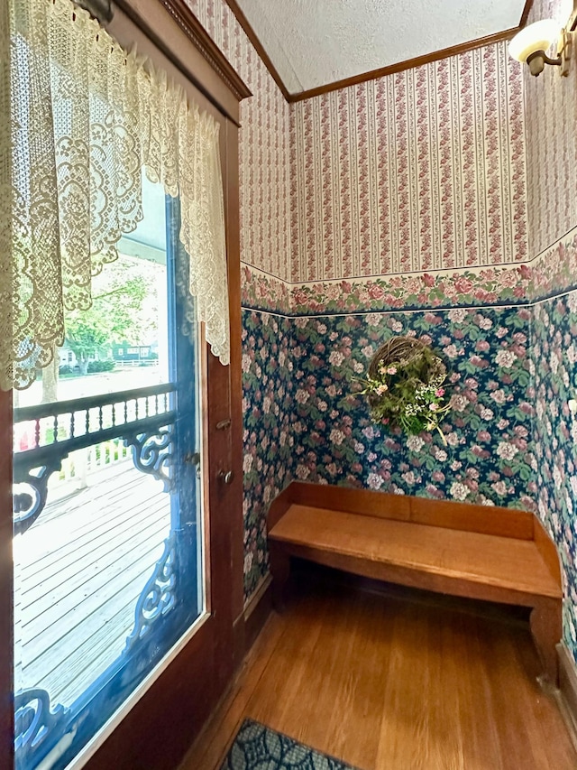 573 Rowland St, Tracy, MN 56175 - entryway with wallpapered walls, wood finished floors, crown molding, and a textured ceiling