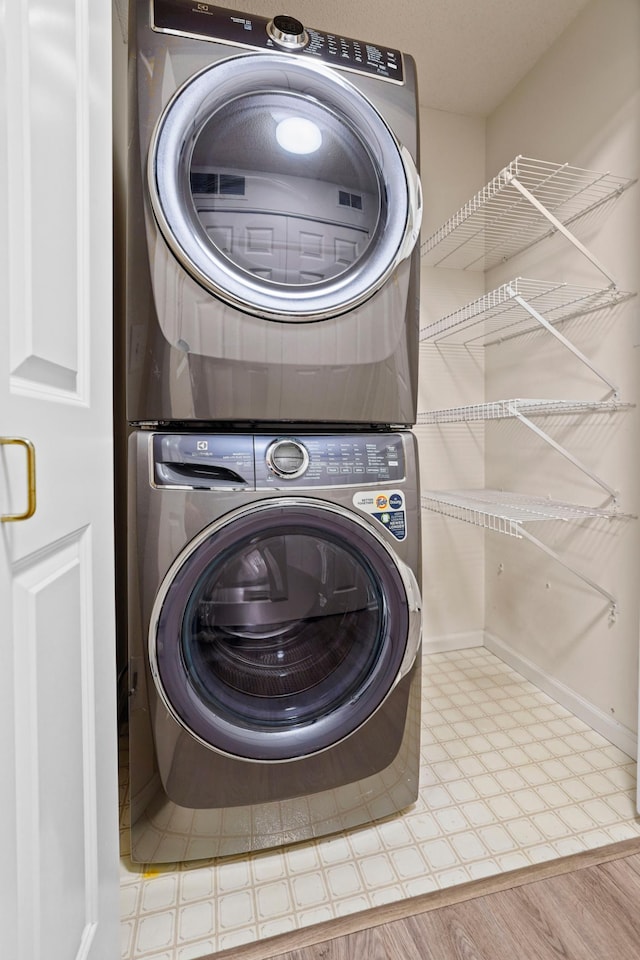 500 2nd St Unit 116, Minneapolis, MN 55401 - washroom with estacked washer and dryer, tile patterned floors, and baseboards