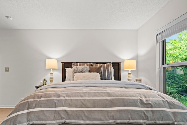 500 2nd St Unit 116, Minneapolis, MN 55401 - bedroom with wood finished floors, a textured ceiling, and baseboards