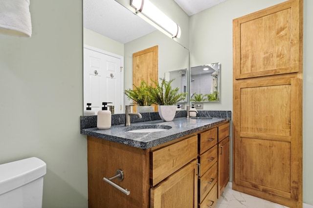 500 2nd St Unit 116, Minneapolis, MN 55401 - bathroom with double vanity, marble finish flooring, and toilet
