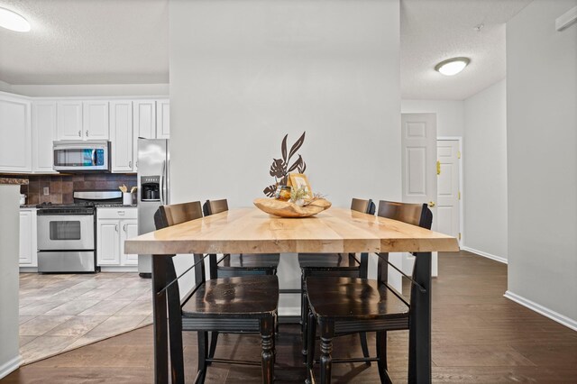 500 2nd St Unit 116, Minneapolis, MN 55401 - dining space featuring a textured ceiling, baseboards, and dark wood finished floors