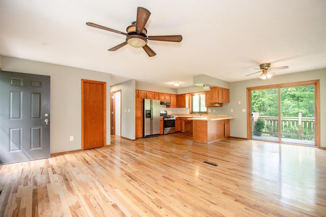 19715 Tyler St NW, Elk River, MN 55330 - kitchen with stainless steel appliances, a ceiling fan, brown cabinets, a peninsula, and light countertops