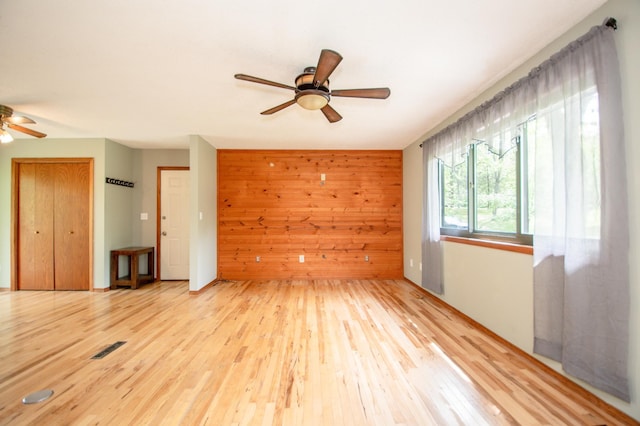 19715 Tyler St NW, Elk River, MN 55330 - unfurnished room featuring a ceiling fan, light wood-style flooring, and wooden walls