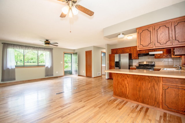 19715 Tyler St NW, Elk River, MN 55330 - kitchen with appliances with stainless steel finishes, light countertops, a peninsula, a sink, and light wood-type flooring
